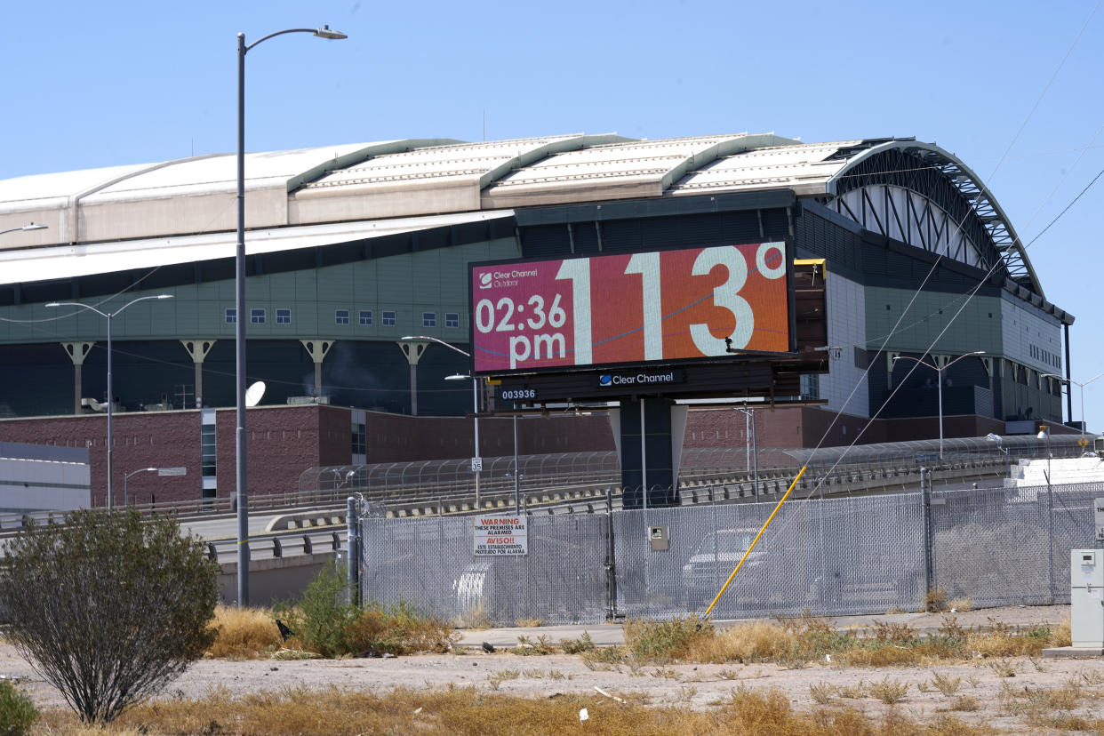 With Chase Field, home of the Arizona Diamondbacks baseball team in the background, a digital billboard updates the time and temperature on July 18, 2023, in Phoenix. (AP Photo/Ross D. Franklin)