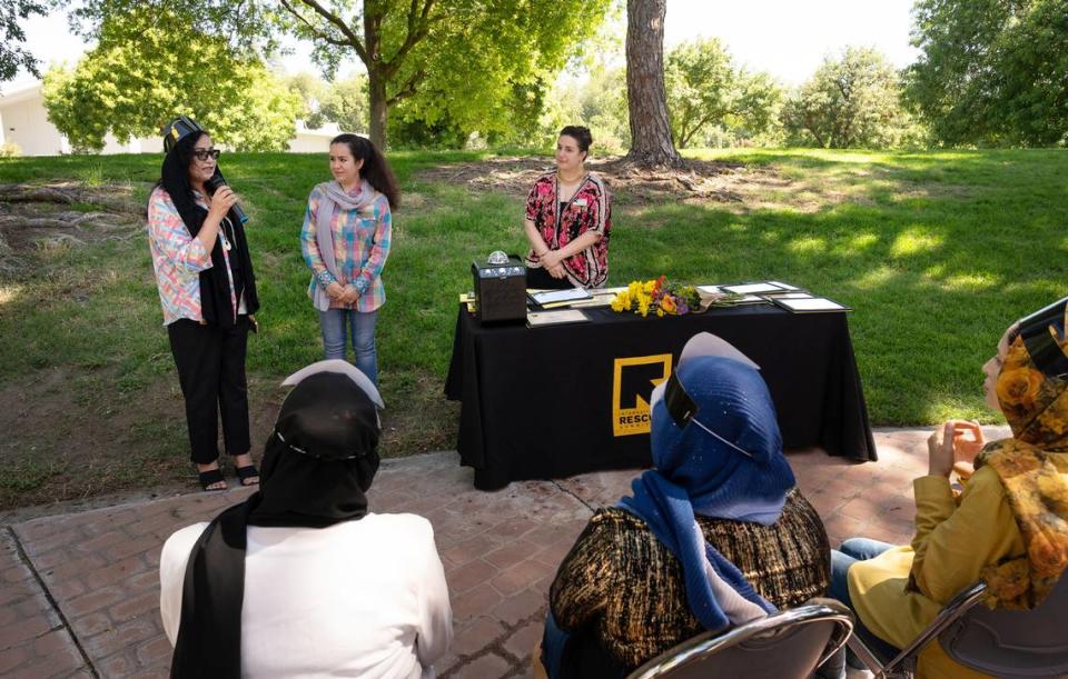 Shekiba Hakibi, left, talks about her experience going through IRC’s child-care microenterprise development program as IRC business counselor Halima Mohammadi, middle, and IRC senior education and health promoter Katharina Beeler, right, listen during a graduation ceremony at Davis Park in Modesto Calif., on Friday, July 1, 2022. Seventeen women refugees from Afghanistan are the first graduates of the International Rescue Committee and Modesto Junior College’s child care microenterprise development program for home child-care licensing.