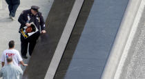 A family member touches one of the names at one of the Twin Memorial pools at Ground Zero during ceremonies marking the 10th anniversary of the 9/11 attacks on the World Trade Center, in New York, September 11, 2011. (REUTERS/Jessica Rinaldi)