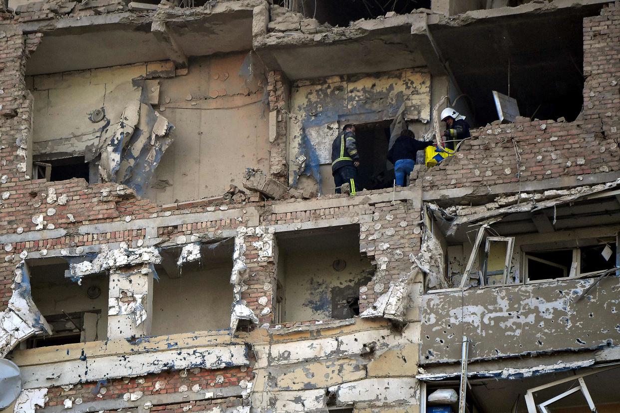 Rescuers evacuate a woman, local resident of a multi storey residential building, partially destroyed after night Russian drones attack in Kyiv (AFP via Getty Images)