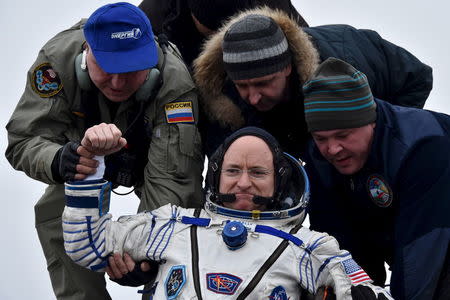 Ground personnel help U.S. astronaut Scott Kelly to get out of a Soyuz capsule shortly after landing near the town of Dzhezkazgan (Zhezkazgan), Kazakhstan, March 2, 2016. REUTERS/Kirill Kudryavtsev/Pool