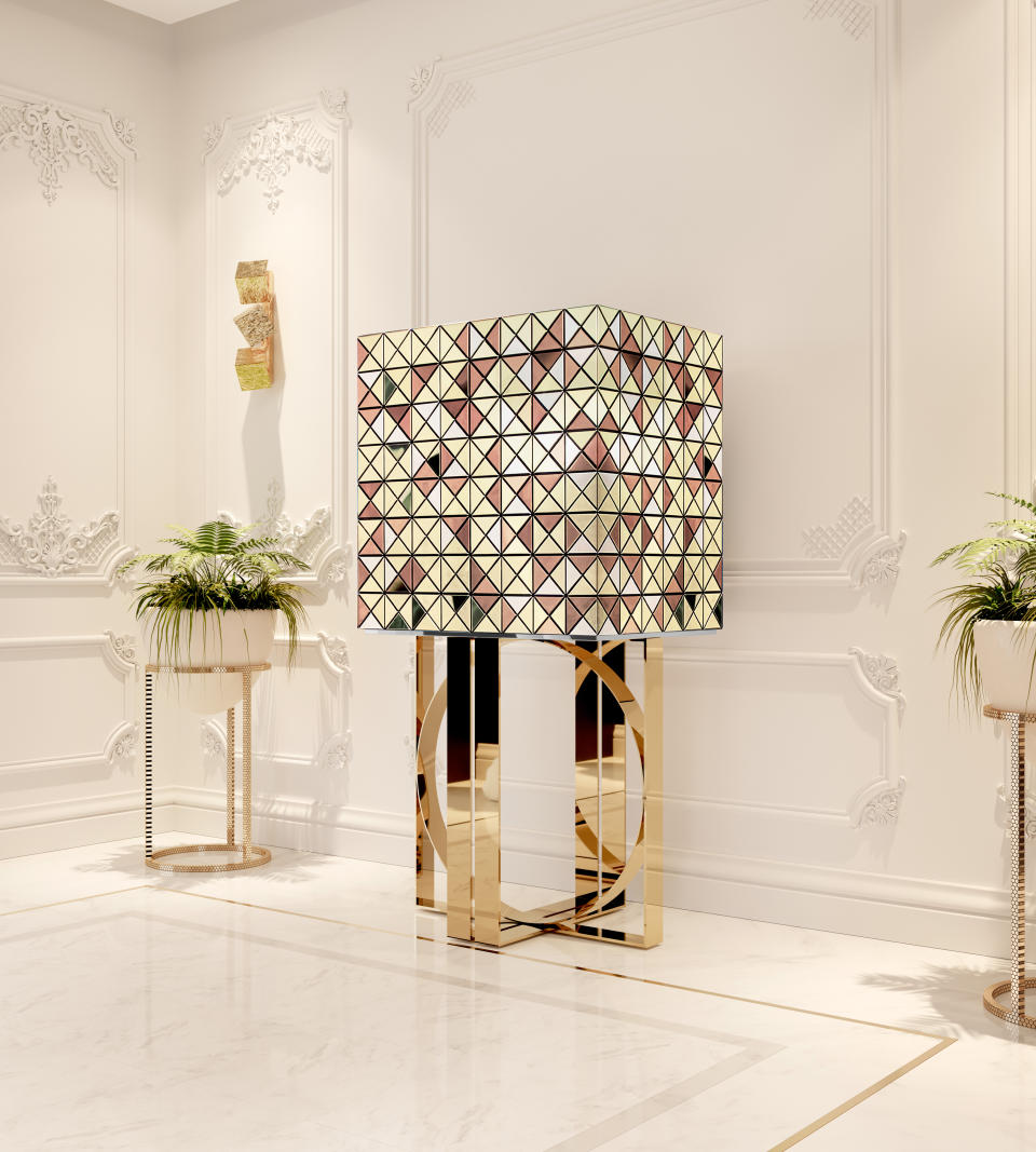 This image released by Boca do Lobo shows the Pixel bar cabinet, clad in over a thousand multicolored triangles made of woods like palisander and African walnut, evoking a pixelated image. Inside, mirror and diamond-quilted blue silk showcases nine drawers, each with a golden knob. (Boca do Lobo via AP)