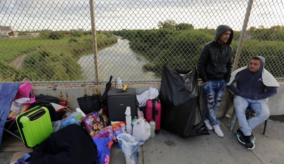 FILE - In this Nov. 2, 2018, file photo, Yenly Morales,left, and Yenly Herrera, right, immigrants from Cuba seeking asylum in the United States, wait on the Brownsville and Matamoros International Bridge in Matamoros, Mexico. The U.S. government will expand its policy requiring asylum seekers to wait outside the country in one of Mexico's most dangerous cities. According to officials for two congressional Democrats, the Department of Homeland Security says it will implement its "Migrant Protection Protocols" in Brownsville, Texas, across the border from Matamoros, Mexico. Matamoros is in Mexico's Tamaulipas state, which the U.S. government warns citizens not to visit due to violence and kidnappings.(AP Photo/Eric Gay, File)