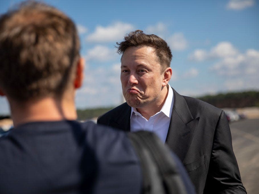 Tesla head Elon Musk talks to one visitor as he arrives to to have a look at the construction site of the new Tesla Gigafactory near Berlin