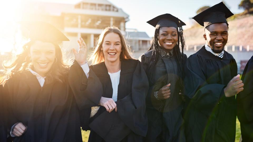 Portrait of a group of students standing together on graduation day.