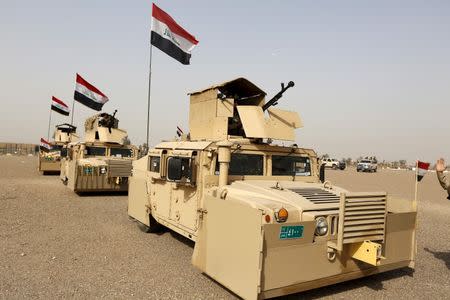 Iraqi security forces ride in vehicles travelling to Mosul to fight against militants of Islamic State at an Iraqi army base in Camp Taji in Baghdad, February 21, 2016. REUTERS/Ahmed Saad