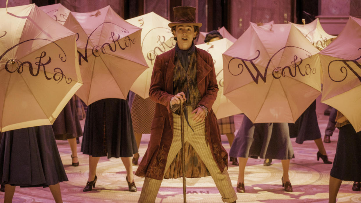  Timothée Chalamet stands in the middle of an umbrella filled musical number in Wonka. 