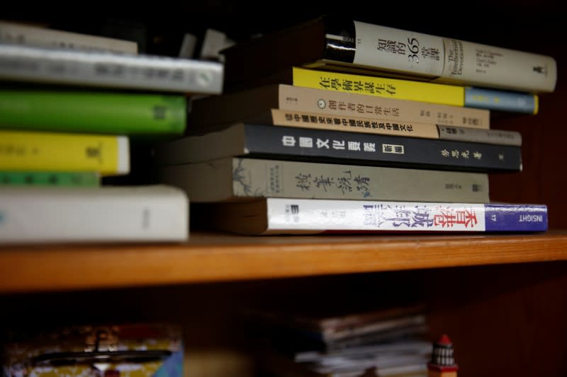 Books belonging to Derek Tai are seen inside his apartment in Hong Kong