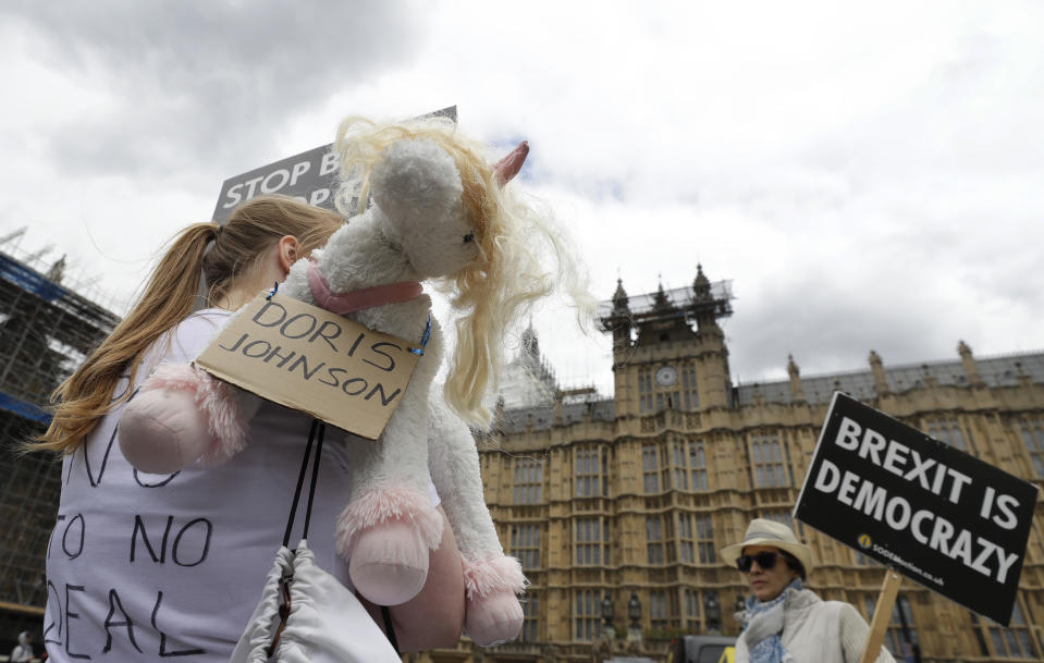 Anti-Brexit remain supporters, one with a 'Doris Johnson' unicorn, protest outside the Houses of Parliament in London, Thursday, June 20, 2019. The contest to become Britain's next prime minister is down to its final three candidates, with Environment Secretary Michael Gove and Foreign Secretary Jeremy Hunt chasing front-runner Boris Johnson for a spot in a deciding runoff. (AP Photo/Kirsty Wigglesworth)