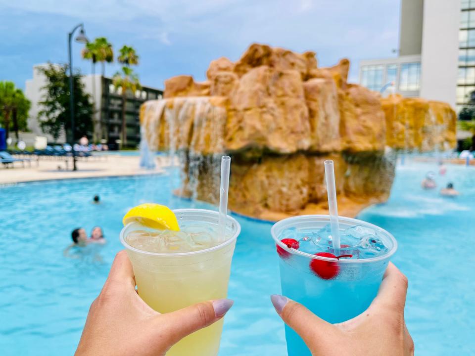 people cheersing drinks at the pool of the disney springs wyndham hotel