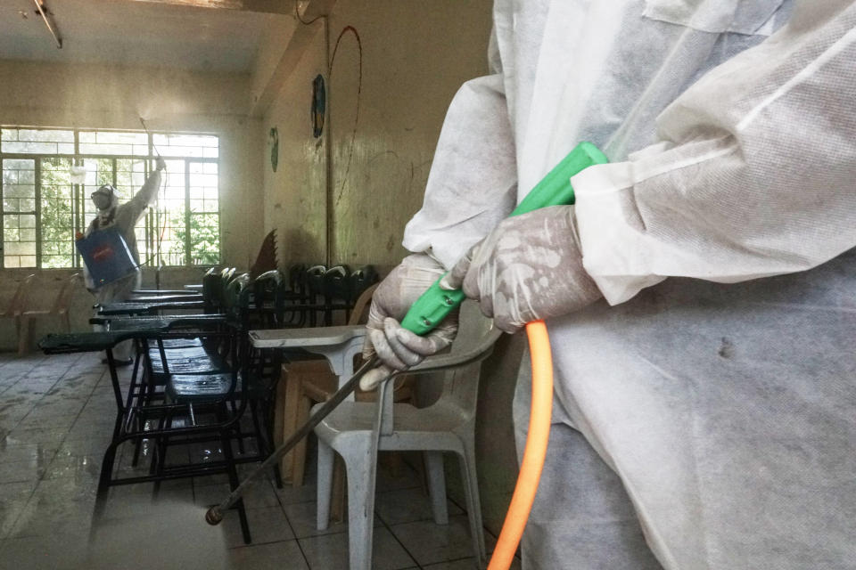 FILE PHOTO: Workers wears hazmat suits as they disinfect and sanitize as precautionary measure against coronavirus at a public school in the City of San Juan in Philippines on March 09, 2020. (Photo: DANTE DIOSINA JR/Anadolu Agency via Getty Images)