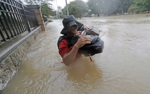 Residents in Houston wade through floodwaters - Credit: AP Photo/David J. Phillip