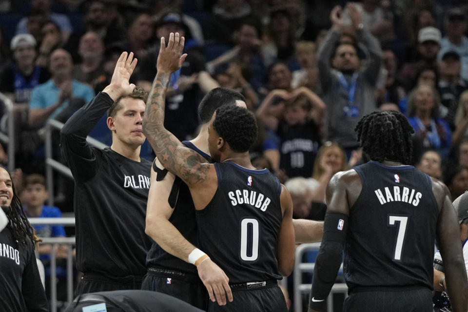 Orlando Magic's Jay Scrubb (0) is congratulated by teammates after making a 3-point shot at the buzzer to end the first quarter of an NBA basketball game against the Cleveland Cavaliers, Thursday, April 6, 2023, in Orlando, Fla. (AP Photo/John Raoux)
