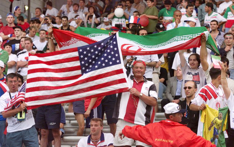 En esta foto de archivo tomada el 21 de junio de 1998, seguidores iraníes y estadounidenses agitan sus banderas nacionales mientras animan a sus equipos durante el partido de fútbol de la Copa del Mundo de Francia 1998