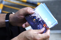 Olympic volunteer Atsushi Muramatsu shows photos of Russian rescuers he took at Sekisui Heim Super Arena on March 18, 2011, when it was used as a morgue following a devastating March 2011 earthquake, during an interview with The Associated Press in Rifu, Japan, Thursday, July 29, 2021. The Tokyo Olympics was billed as the “Recovery and Reconstruction Games,” with the torch relay starting in disaster-hit Fukushima and several events held in Fukushima and Miyagi. However, the coronavirus pandemic has disrupted opportunities to showcase the region’s restoration to foreign spectators. (AP Photo/Chisato Tanaka)