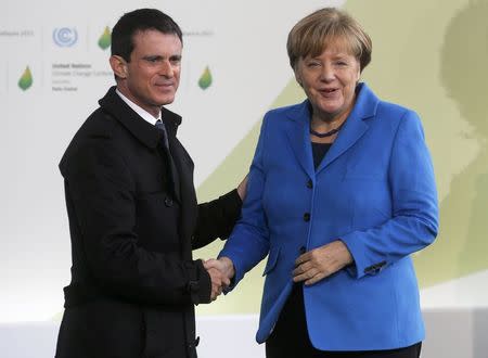 French Prime Minister Manuel Valls (L) welcomes German Chancellor Angela Merkel as she arrives for the opening day of the World Climate Change Conference 2015 (COP21) at Le Bourget, near Paris, France, November 30, 2015. REUTERS/Christian Hartmann