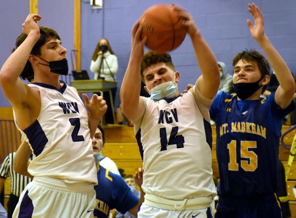 West Canada Valley Indian Michael Tubia Jr (14) grabs an offensive rebound between teammate Will Smith (2) and Mt. Markham Mustang Ethan Siega (15) during the third quarter of Thursday's game.