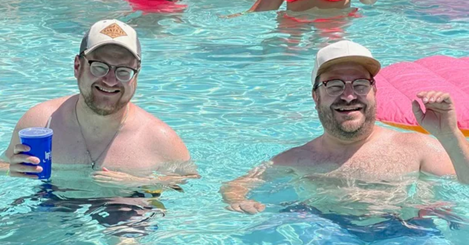 A man in a pool with another man who looks identical to him. 