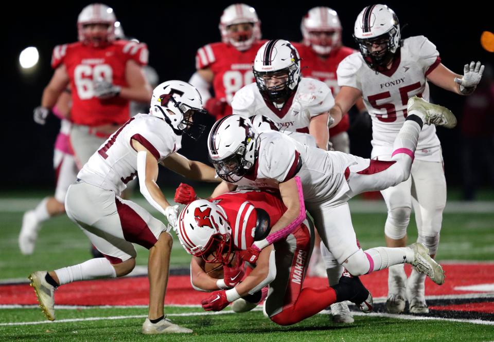 Kimberly's Blake Barry (6) is brought down by Fond du Lac High's Halden Krueger (9) during their football game Friday in Kimberly.