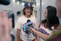 Samantha Sheffield, right, looks on as her son Braylon Sheffield, 14, both of Fort Myers, Fla., gives an interview after the first baseball game of a doubleheader between the New York Yankees and Texas Rangers in Arlington, Texas, Tuesday, Oct. 4, 2022. Braylon caught a home run ball hit by Yankees' Oswald Peraza. A security guard told the Sheffields the Yankees would like the ball, which they gladly handed over. After the game, they met with Peraza outside the visitors’ clubhouse and received some signed baseballs and tickets to a future Yankees game in Arlington. (AP Photo/LM Otero)