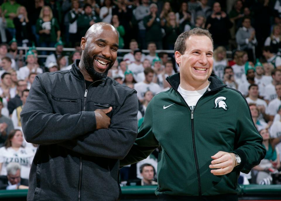 Former Michigan State players Mateen Cleaves left, and Mat Ishbia laugh as they are introduced with Michigan State's 2000 national championship team during halftime of the Michigan State-Florida NCAA college basketball game on Dec. 12, 2015, in East Lansing, Mich.