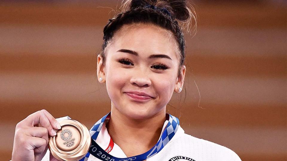 Gymnast Suni Lee (pictured) celebrates with her Olympic gold medal.