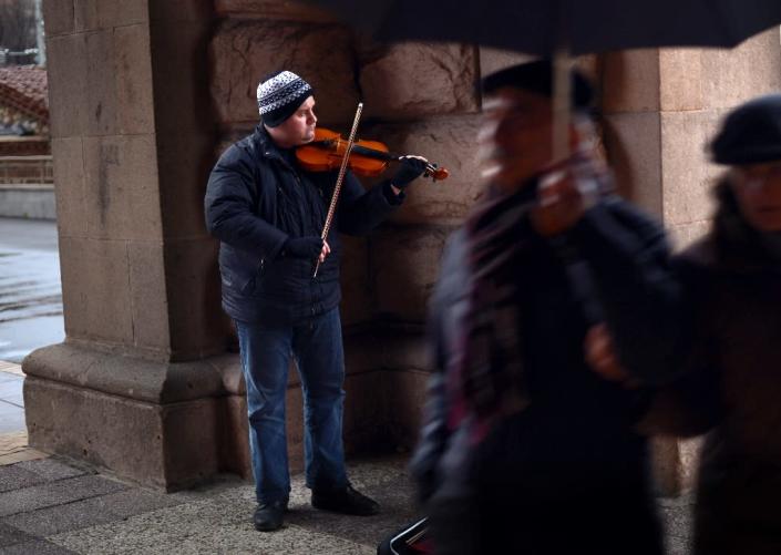 Martin Koleshev, who lives with his parents in a one bedroom flat in the town of Buhovo outside Sofia, plays the violin in the street in central Sofia on April 1, 2015 (AFP Photo/Nikolay Doychinov)