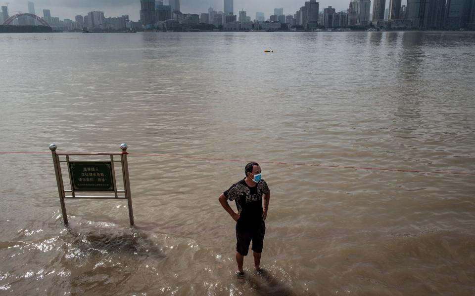  A man standing on a flooded street on the banks of the Yangtze River after heavy rain in Wuhan in China's central Hubei province - AFP