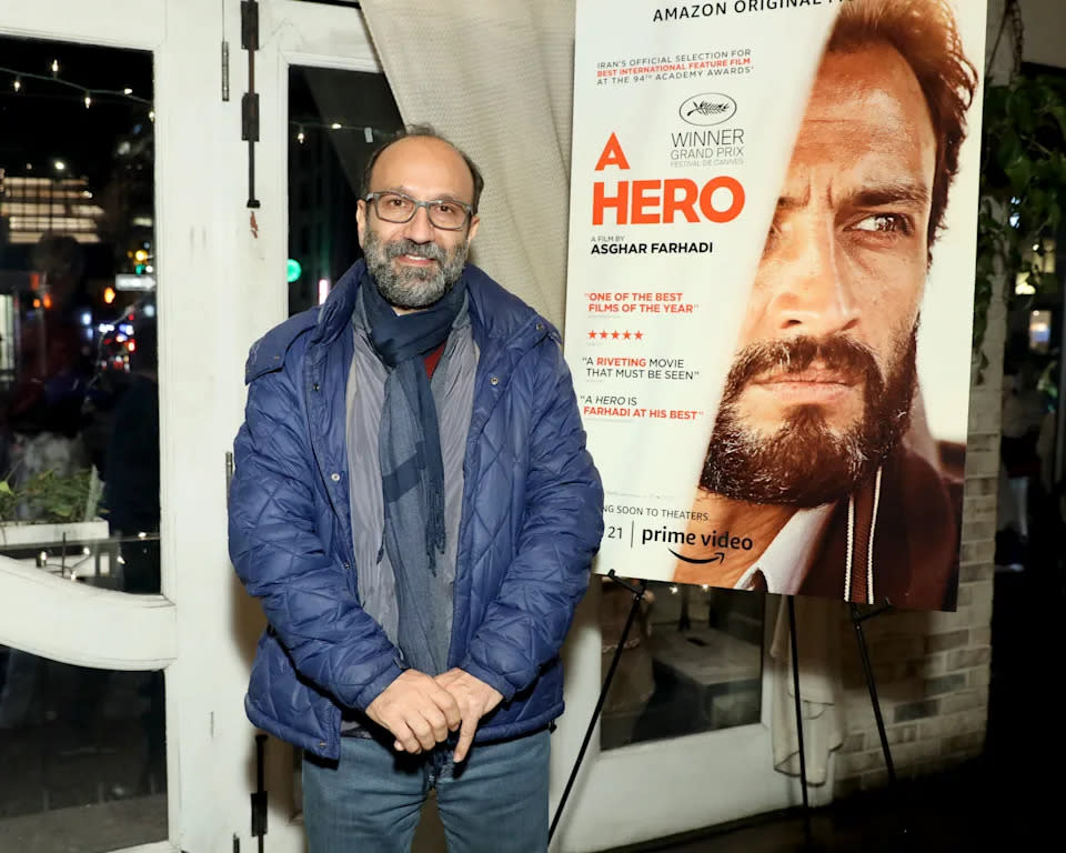 伊朗導演阿斯加法哈迪（Asghar Farhadi）在自己的新電影《A Hero》海報旁擺好姿勢拍照：這部電影原先預計會角逐「最佳原創劇本」獎項（圖片來源：Monica Schipper/Getty Images）