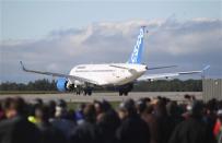 Bombardier employees and guests watch the CSeries aircraft taxi on the runway for its first test flight in Mirabel, Quebec, September 16, 2013. REUTERS/Christinne Muschi