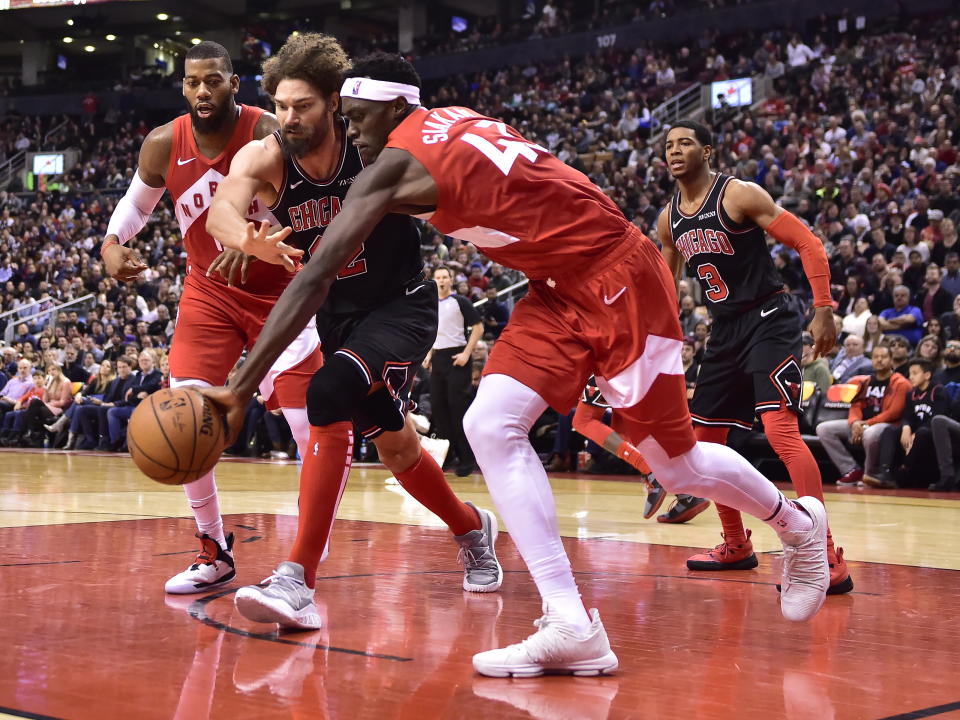 Toronto Raptors forward Pascal Siakam (43) collects a rebound in front of Chicago Bulls center Robin Lopez (42) during second-half NBA basketball game action in Toronto, Ontario, Sunday, Dec. 30, 2018. (Frank Gunn/The Canadian Press via AP)