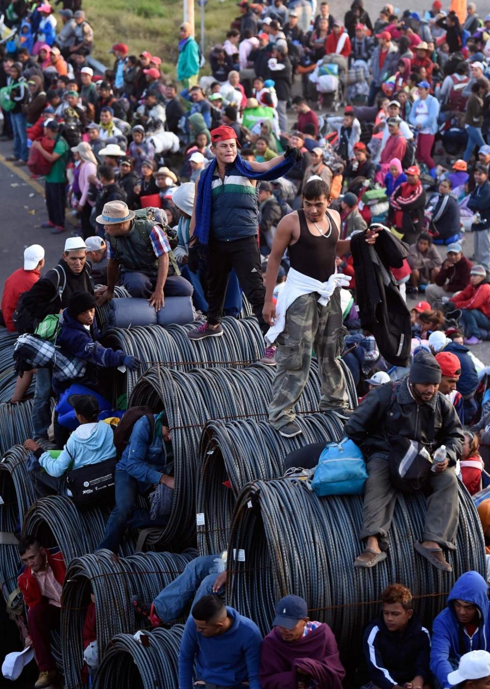 Young people board a lorry carrying reels of wiring as they take whatever lift they can find toward the US. Local officials prevents many migrants from waylaying trucks, but made sure they could hitch a ride with bus operators and other motorists. (AFP/Getty/Alfredo Estrella)