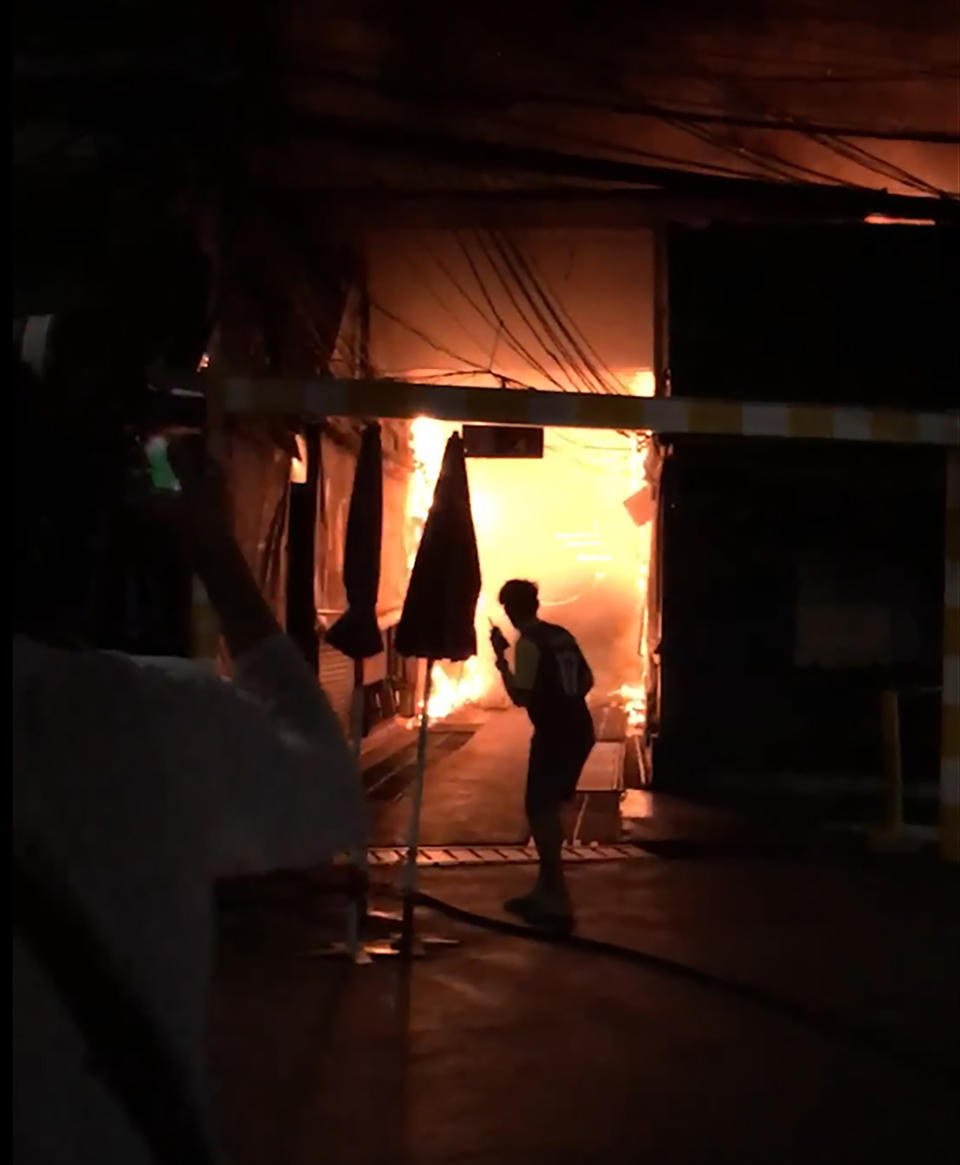 This Sunday, June 2, 2019 image taken from video provided by Younes Parvin shows a fire at Bangkok's Chatuchak weekend market, Thailand. Thai authorities are investigating an after-hours fire that roared through Chatuchak market, destroying dozens of the small shops crammed inside one of Asia's most popular bazaars. (Younes Parvin via AP Photo)