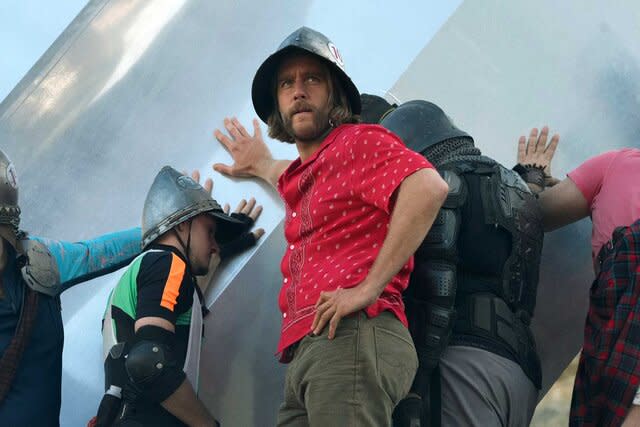 Jake McDorman as Wiley leaning against an object with a helmet on