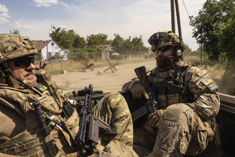 Ukrainian servicemen of "Fireflies" reconnaissance team ride to the position in the trunk of pickup at the frontline in Mykolaiv region, Ukraine, on Monday, Aug. 8, 2022. (AP Photo/Evgeniy Maloletka)