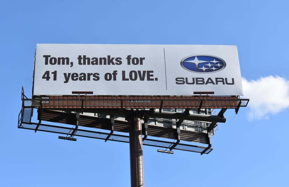 A billboard across from Subaru of America headquarters in Camden salutes the firm's retired president and CEO Thomas Doll.