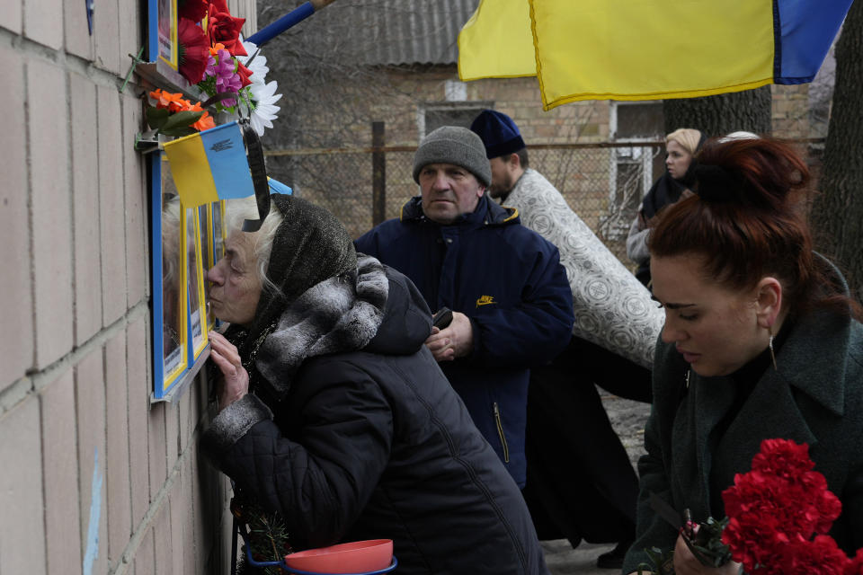 Anna Levchenko, 81, kisses the picture of her grandson Andrii Matviichuk, during a gathering to mark the first anniversary of the death of eight men killed by Russian forces in Bucha, Ukraine, Saturday, March 4, 2023. The eight had set up a roadblock on a road in the town in an attempt to prevent Russian troops from advancing, as they swept towards the Ukrainian capital at the start of their invasion. (AP Photo/Thibault Camus)