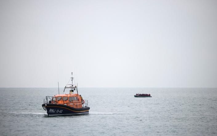 Migrants are escorted ashore by a RNLI Lifeboat, after having crossed the channel, in Dungeness, Britain