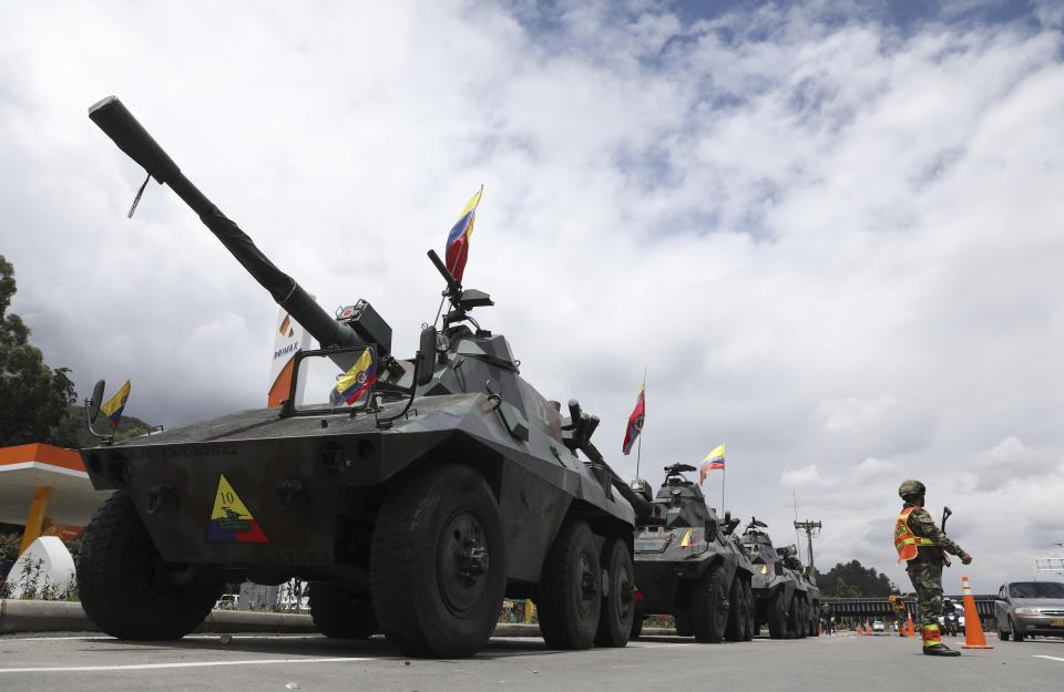 Soldiers and army tanks guard toll booths to keep protesters from damaging them, on the outskirts of Bogota, Colombia, Tuesday, May 4, 2021. Colombia’s finance minister resigned on Monday following five days of protests over a tax reform proposal that left at least 17 dead. (AP Photo/Fernando Vergara)