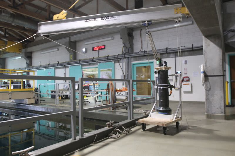 A robotic near-shore ocean float sits on a cart next to a test tank at the Monterey Bay Aquarium Research Institute in Moss Landing