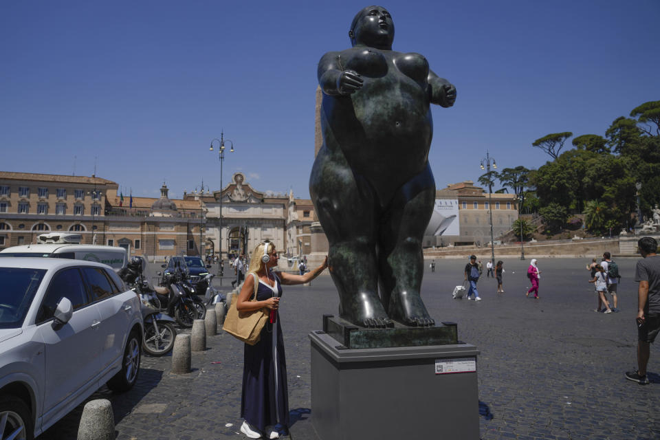 Una mujer toca la escultura "Eva", de Fernando Botero, en la Plaza del Popolo, en Roma, el 19 de julio de 2024. Las calles y plazas de Roma son un vibrante lienzo para las exuberantes esculturas de Botero, convirtiendo la ciudad en un museo al aire libre para las voluminosas formas creadas por el colombiano. (AP Foto/Gregorio Borgia)