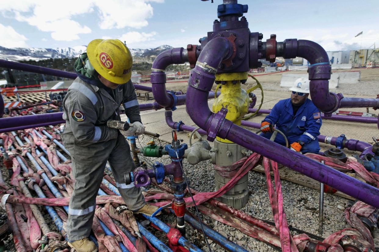 <span>Workers tend to a well head in western Colorado on 29 March 2013.</span><span>Photograph: Brennan Linsley/AP</span>