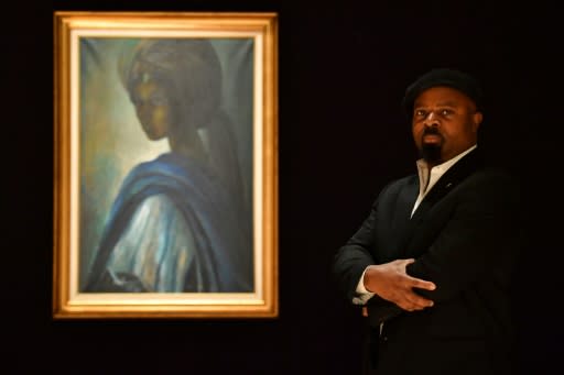 Nigerian author Ben Okri poses last year with Ben Enwonwu's 'Tutu' known as the 'African Mona Lisa'