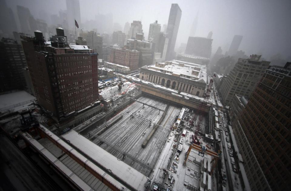 Early snowfall blankets ongoing construction of a platform for a twin tower hi-rise project, covering the Penn Station rail tracks on Tuesday, Jan. 21, 2014 in New York. Weather forecast calls for snow through mid-afternoon with temperatures steady in the low 20s. (AP Photo/Bebeto Matthews)