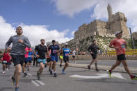 Runners compete in the Jerusalem Winner Marathon, as they pass the Old City of Jerusalem, Friday, March 8, 2024. (AP Photo/Ohad Zwigenberg)