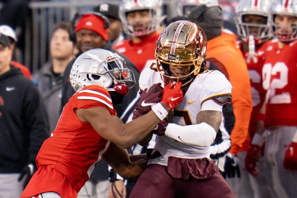 Ohio State cornerback Davison Igbinosun tackles Minnesota wide receiver Daniel Jackson during the Buckeyes' 37-3 win Saturday.