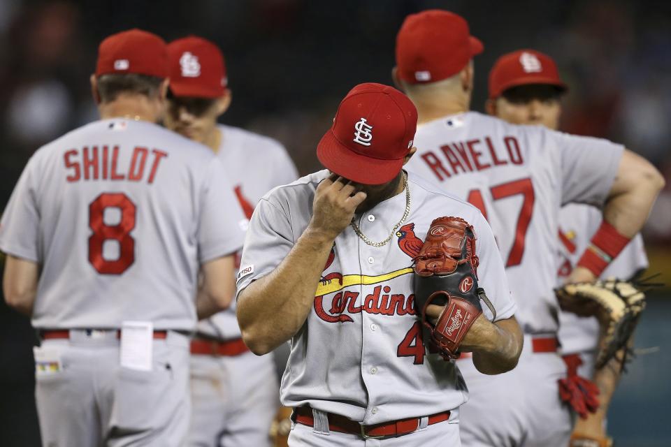 St. Louis Cardinals relief pitcher Junior Fernandez, right, walks back to the dugout after being taking out of the baseball game by manager Mike Shildt (8) after giving up four runs against the Arizona Diamondbacks during the sixth inning Wednesday, Sept. 25, 2019, in Phoenix. (AP Photo/Ross D. Franklin)