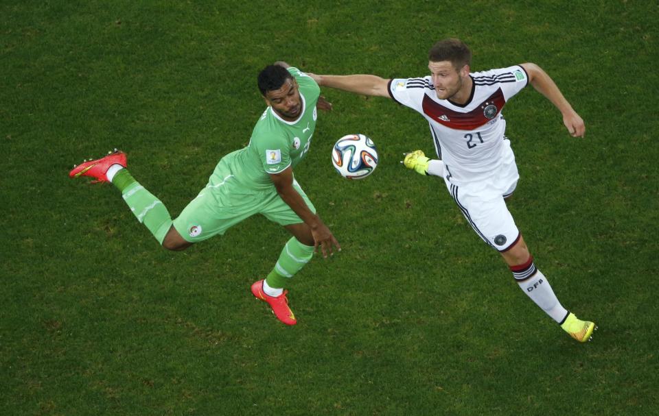 Algeria's El Arabi Soudani (L) fights for the ball with Germany's Shkodran Mustafi during their 2014 World Cup round of 16 game at the Beira Rio stadium in Porto Alegre June 30, 2014. REUTERS/Fabrizio Bensch
