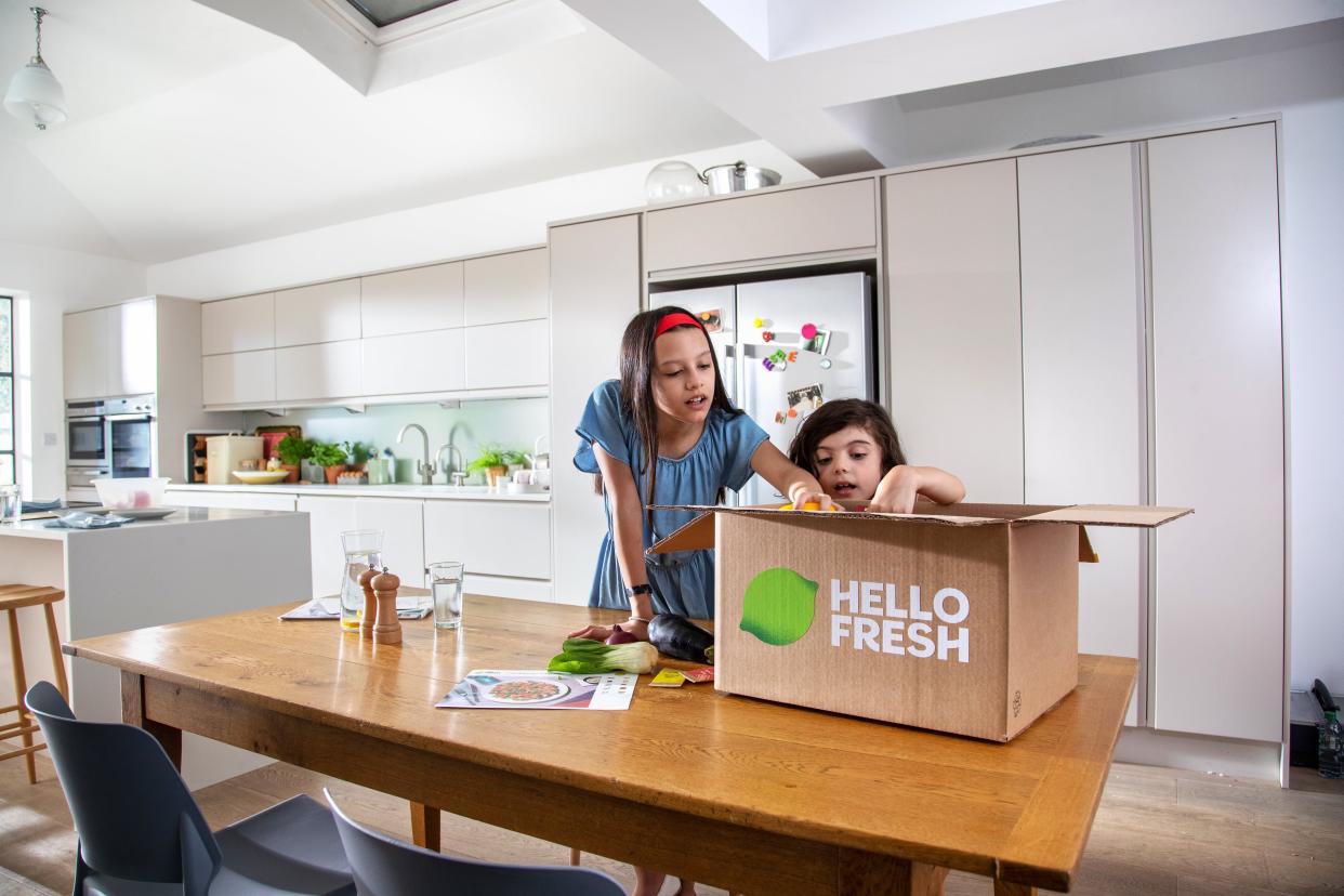 Two children unboxing HelloFresh meal kit delivery