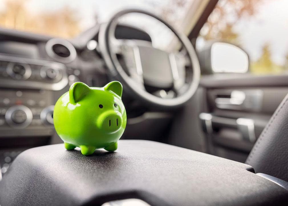 Green piggy bank money box in car interior, vehicle purchase, insurance or driving and motoring cost